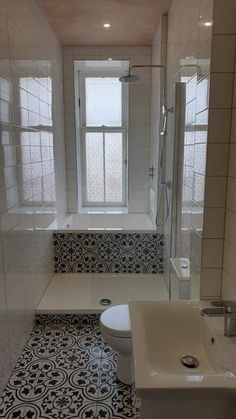 a bathroom with black and white tiles on the floor