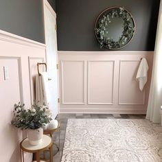 a bathroom with gray walls and white trim on the walls, along with a round mirror