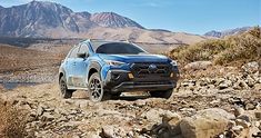 a blue subarunt is driving down a rocky trail