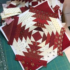 several pieces of red and white quilts laid out on top of a cutting board