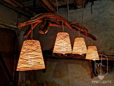 five lamps hanging from a tree branch in a room