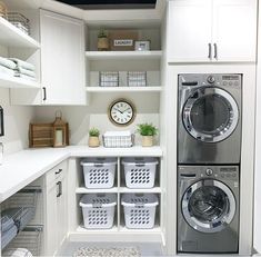 a washer and dryer in a small room with white cabinets on the walls