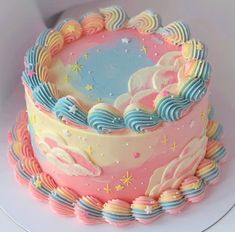 there is a colorful cake with clouds and stars on it