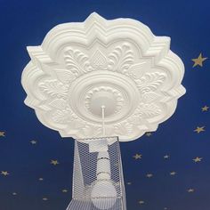 a white decorative object with stars in the background