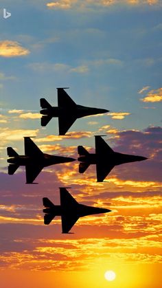 four fighter jets flying in formation at sunset