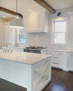 a large kitchen with white cabinets and an island