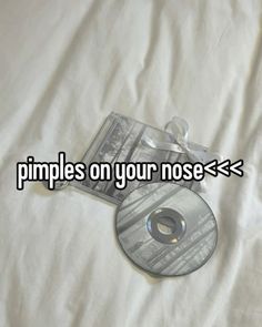 a cd sitting on top of a white sheet with the words pimples on your nose