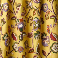 a yellow curtain with colorful flowers and leaves on it