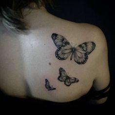 the back of a woman's shoulder with three butterflies on her left shoulder and right shoulder