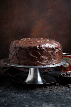 a chocolate cake sitting on top of a metal plate next to a can of coke