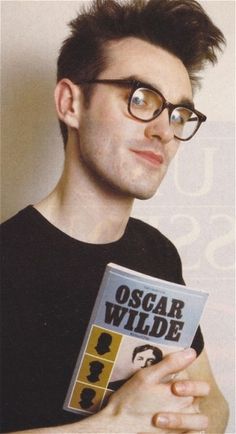 a man with glasses is holding a book