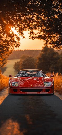 a red sports car parked on the side of a country road at sunset or dawn