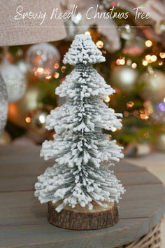 a small white christmas tree sitting on top of a wooden table