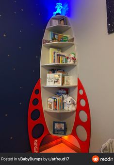 a space shuttle shaped book shelf with books on the top and shelves below it in a child's room