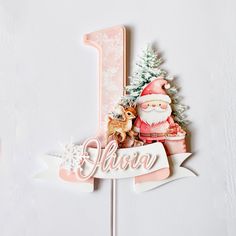 a cake topper with a santa clause and reindeer on it's number one