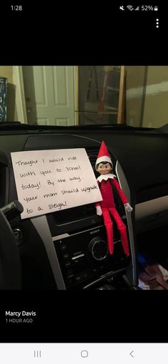 an elf is sitting in the driver's seat of a car with a note attached to it