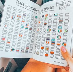 a person holding an open book in their hand with flags of countries printed on it