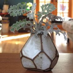 a vase filled with flowers sitting on top of a wooden table next to a couch