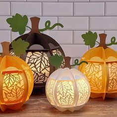 three paper pumpkins sitting next to each other on a table