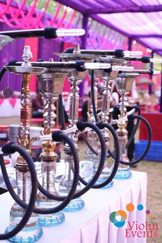 an assortment of silver and gold candelabra on display in front of a tent