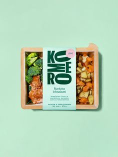 an open box of food with broccoli and carrots on the inside, against a green background