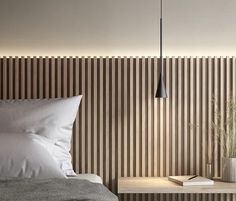 a bed with white sheets and pillows next to a wooden wall