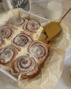 a pan filled with cinnamon rolls covered in icing