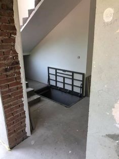 an empty room with stairs leading up to the second floor and another area in the background