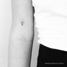 a small light bulb tattoo on the arm