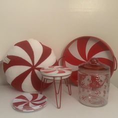 red and white candy canes are sitting on the table next to a glass jar