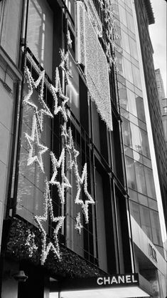 black and white photograph of chanel storefront with christmas lights on the windows, new york city