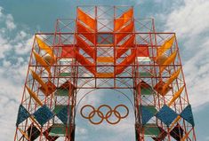 the olympic rings are made out of scaffoldings and orange, yellow, blue, and green