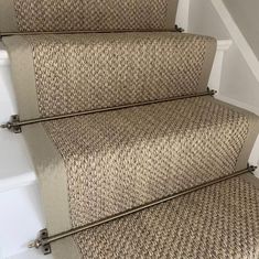 some beige carpeted stairs with metal handrails