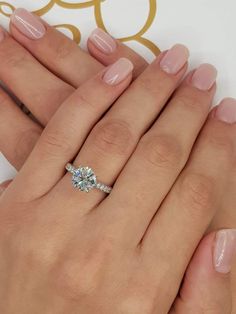 two women's hands with rings and manicures on their fingers, one holding the other