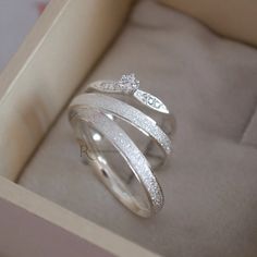 a ring in a box with two diamonds on it's sides and one diamond set at the top