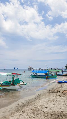 there are many small boats on the water at this beach and one boat is in the distance