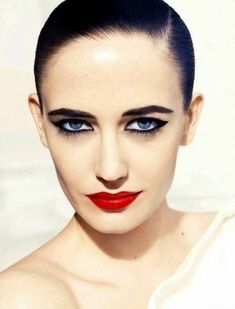 a woman with bright blue eyes and red lipstick on her face is posing for the camera