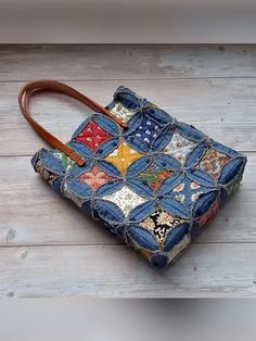 a handbag made out of old jeans and patchwork on the outside, sitting on a wooden floor