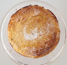 a cake sitting on top of a plastic plate covered in powdered sugar and sprinkles