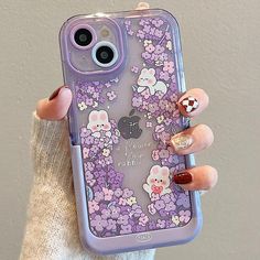 a woman holding up her phone case with flowers and bears painted on the back in purple