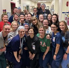 a group of people in scrubs are posing for a photo at the end of a hospital hallway