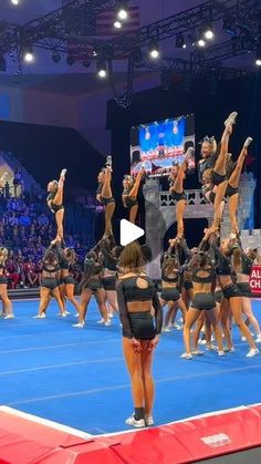 a group of cheerleaders standing on top of a blue court