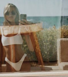 a woman is taking a selfie with her cell phone while sitting at a table