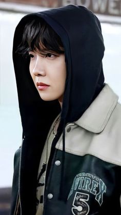 a young man with black hair and a hoodie