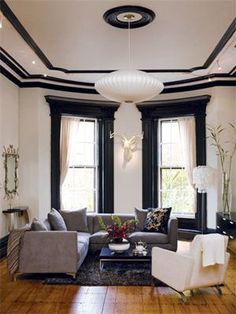 an image of a living room with black and white decor on the walls, couches and windows