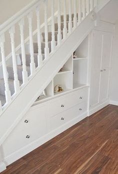 the stairs are built into the wall under the bed and below it is a white cabinet with drawers