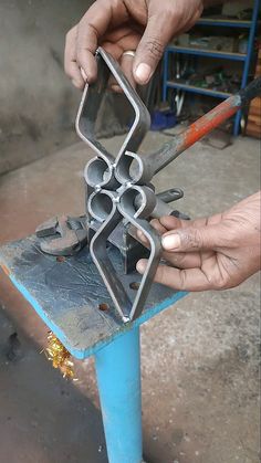 a person is working on something with metal parts in their hands and tools are being used to make the sculpture