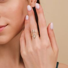 a close up of a person wearing a ring and holding her hand near her ear