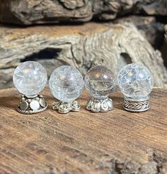 three clear glass knobs sitting on top of a wooden table next to a rock