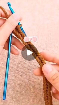 someone is crocheting the end of a piece of yarn with a blue crochet hook